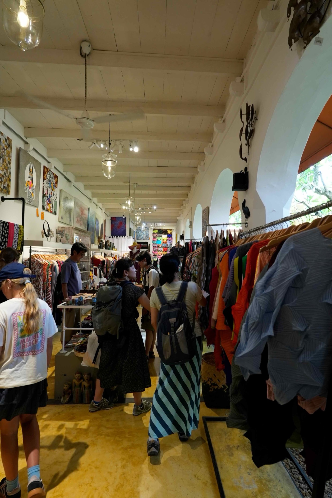 カラフルな服が並ぶ大型ショップ。アート作品も一緒に展示されている