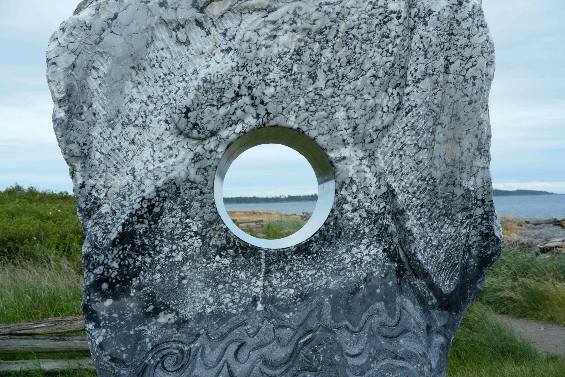 穴の空いた流木と岩のアート