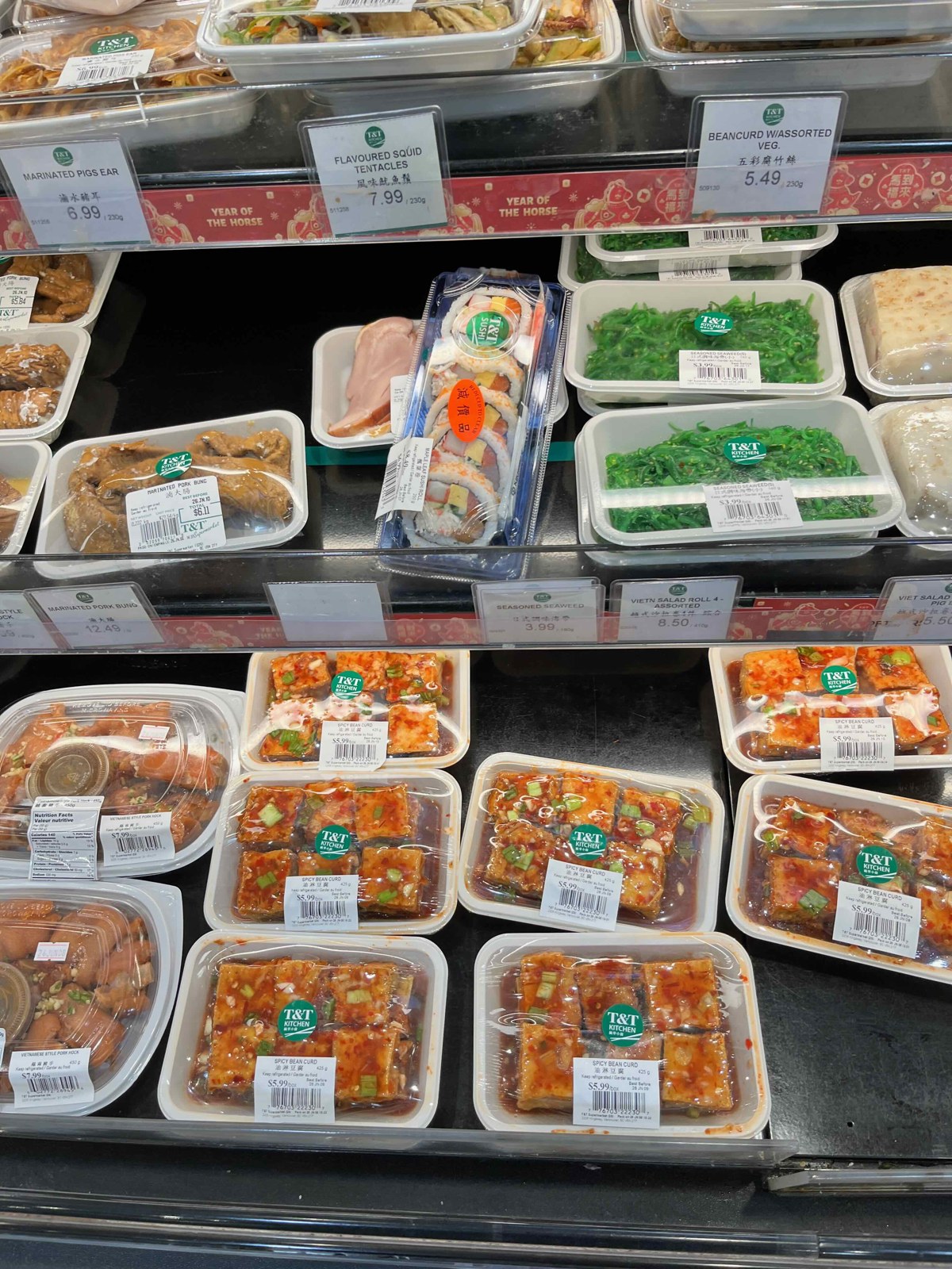 T&Tのお惣菜ショーケース。味付け豆腐や海藻、生春巻き、巻き寿司などが値札付きで並ぶ