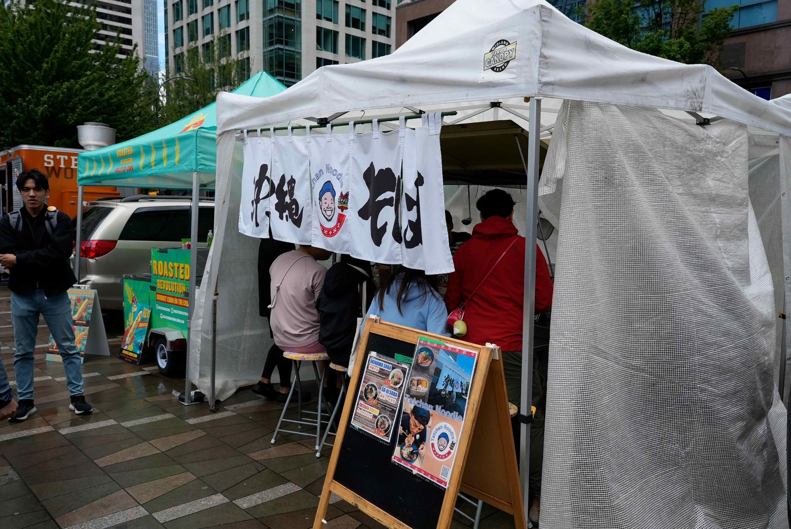「沖縄そば」ののれんがかかった白いテント。列に並ぶ来場者たち