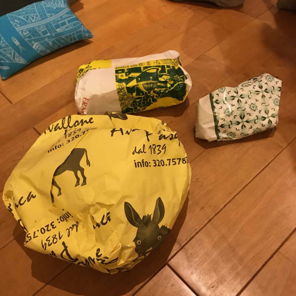 買った陶器の包み。ロバの絵の包装紙と緑の模様の紙